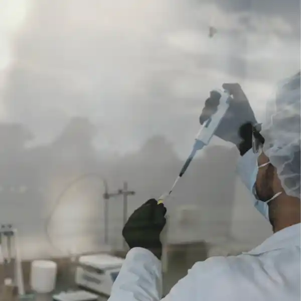 Mann mit Schutzkleidung prüft etwas im Labor